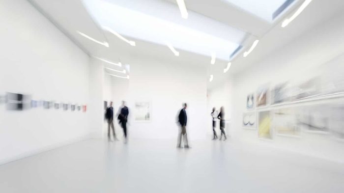 blurred image of people walking around an art gallery